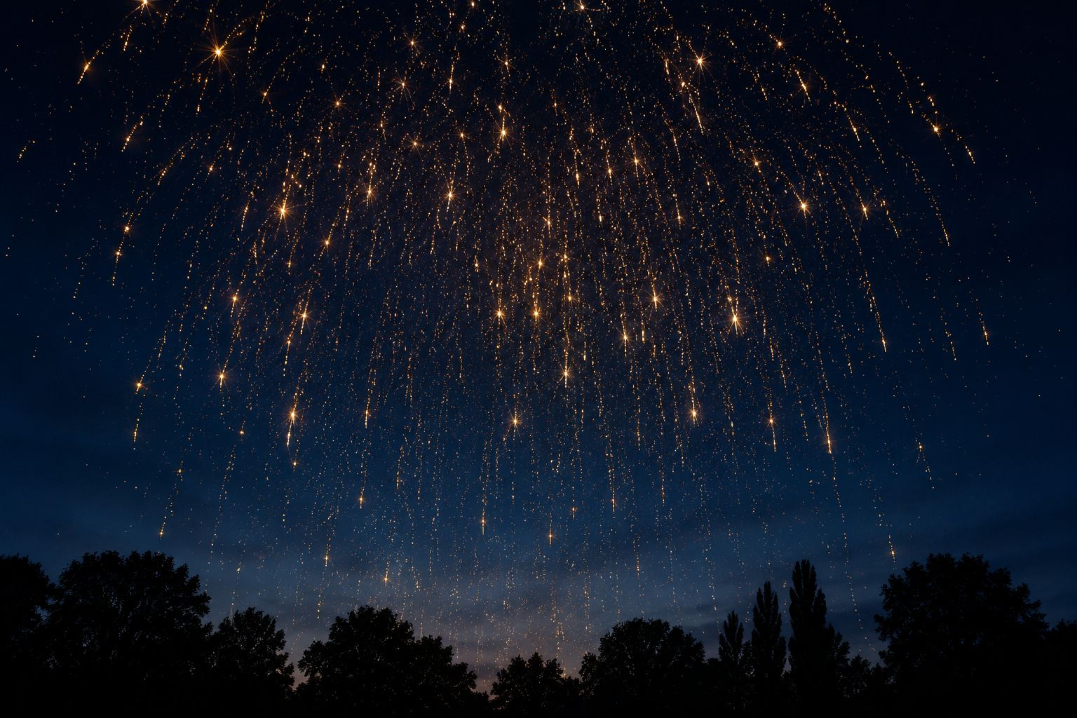 Ciel de nuit constellé d’étincelles retombantes, au-dessus d’une ligne d’arbres